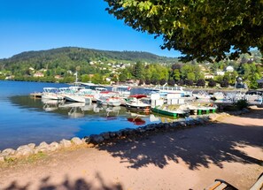 A marina with boats docked, a clear sky, and a hilly landscape in the background. - Homerez - Studio in Gérardmer (Gérardmer)
