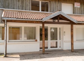 A building with a covered entrance, large windows, and a tiled roof. - Homerez - Studio in Gérardmer (Gérardmer)