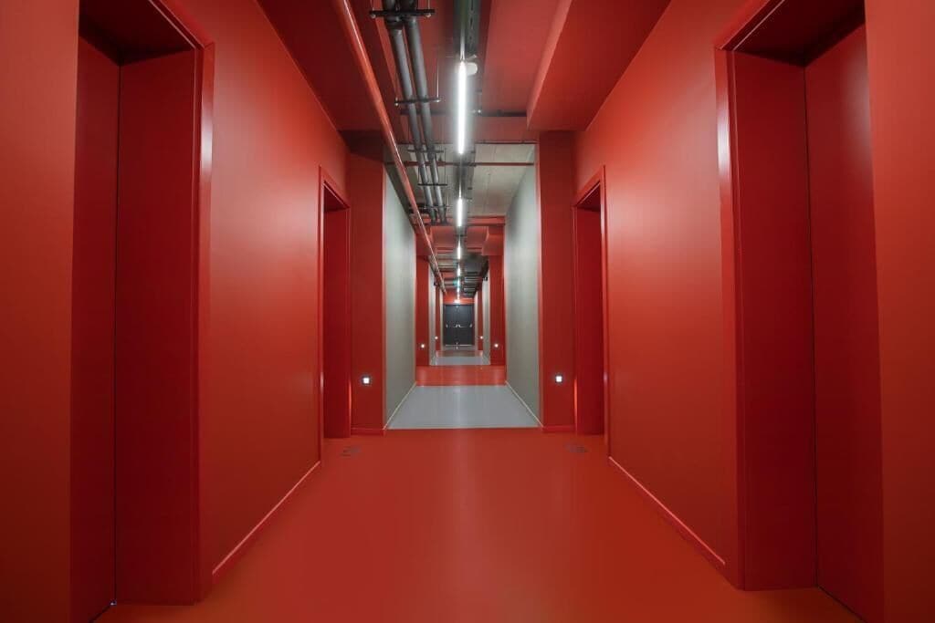 A corridor with red walls and a central walkway.