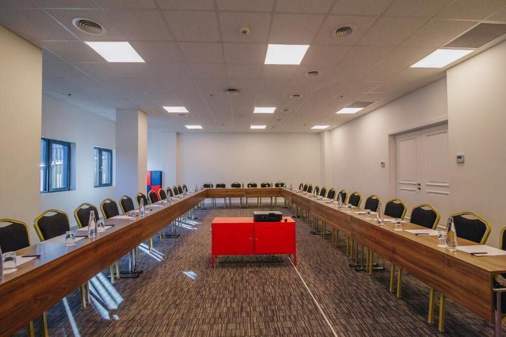 A conference room with a long table, chairs, and a red cabinet.