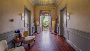 A hallway with a chandelier, two doors labeled 301 and 302, and a view of an outdoor patio. - No 2 Hotel By Şükrü (Adalar)
