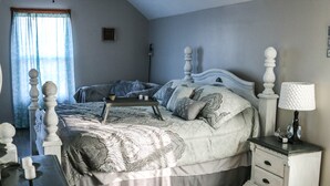 A bedroom with a large bed, a bedside table with a lamp, and a window with curtains. - Large home, Pet friendly (Union)
