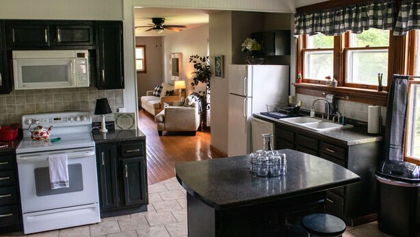 A kitchen with a microwave, stove, and refrigerator. There is a dining area with a table and chairs. - Large home, Pet friendly (Union)