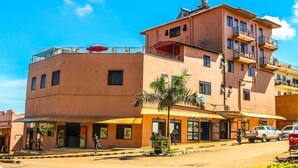 A multi-story building with a ground-level restaurant and a visible sign for a Toyota dealership. - Mbale Travellers Inn (Mbale)