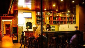 A bar area with stools, a counter, and shelves of bottles. - Mbale Travellers Inn (Mbale)