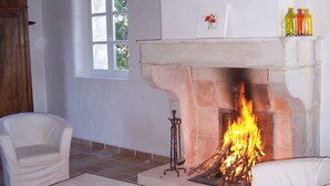 A room with a fireplace, white furniture, and a window. - Stone barn 360 ° view of the Luberon and the Vaucluse mountains (Viens)