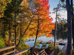 A lakeside view with autumn foliage, wooden docks, and a wooden walkway.