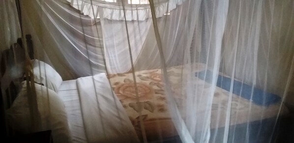 A bed with a canopy and a floral-patterned bedspread.