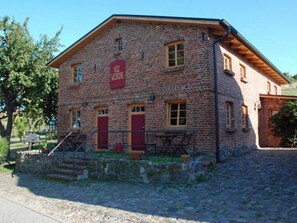 Ein Backsteinhaus mit roter Tür und einem Schild, auf dem 'Hotel' steht.