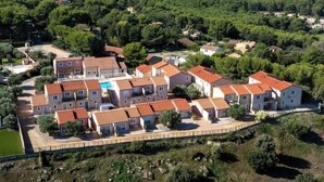 A residential area with multiple two-story houses featuring red-tiled roofs and a central swimming pool. - Appart'hotel Résidence La Provence (Saint-Mitre-les-Remparts)