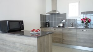 A modern kitchen with a built-in microwave, a coffee maker, and a toaster. - Appart'hotel Résidence La Provence (Saint-Mitre-les-Remparts)