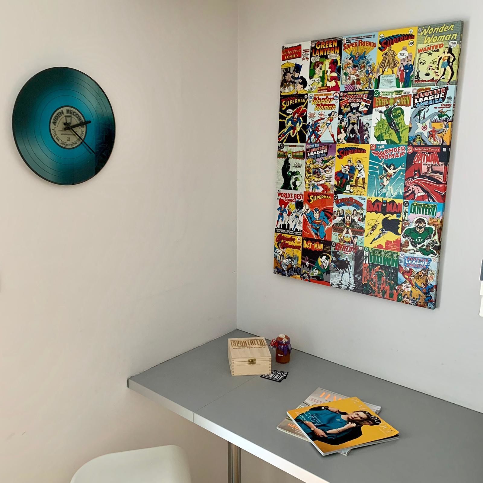 A wall with a collection of comic books and a vinyl record.