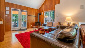 Ein modernes Wohnzimmer mit Kamin, Ledersofa und einem roten Teppich.