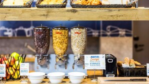 Un bufé de desayuno con diversas opciones de comida, incluyendo cereales y fruta.