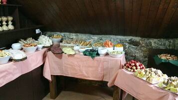 Ein reichhaltiges Buffet mit verschiedenen Speisen auf Tischen mit karierten Tischdecken.