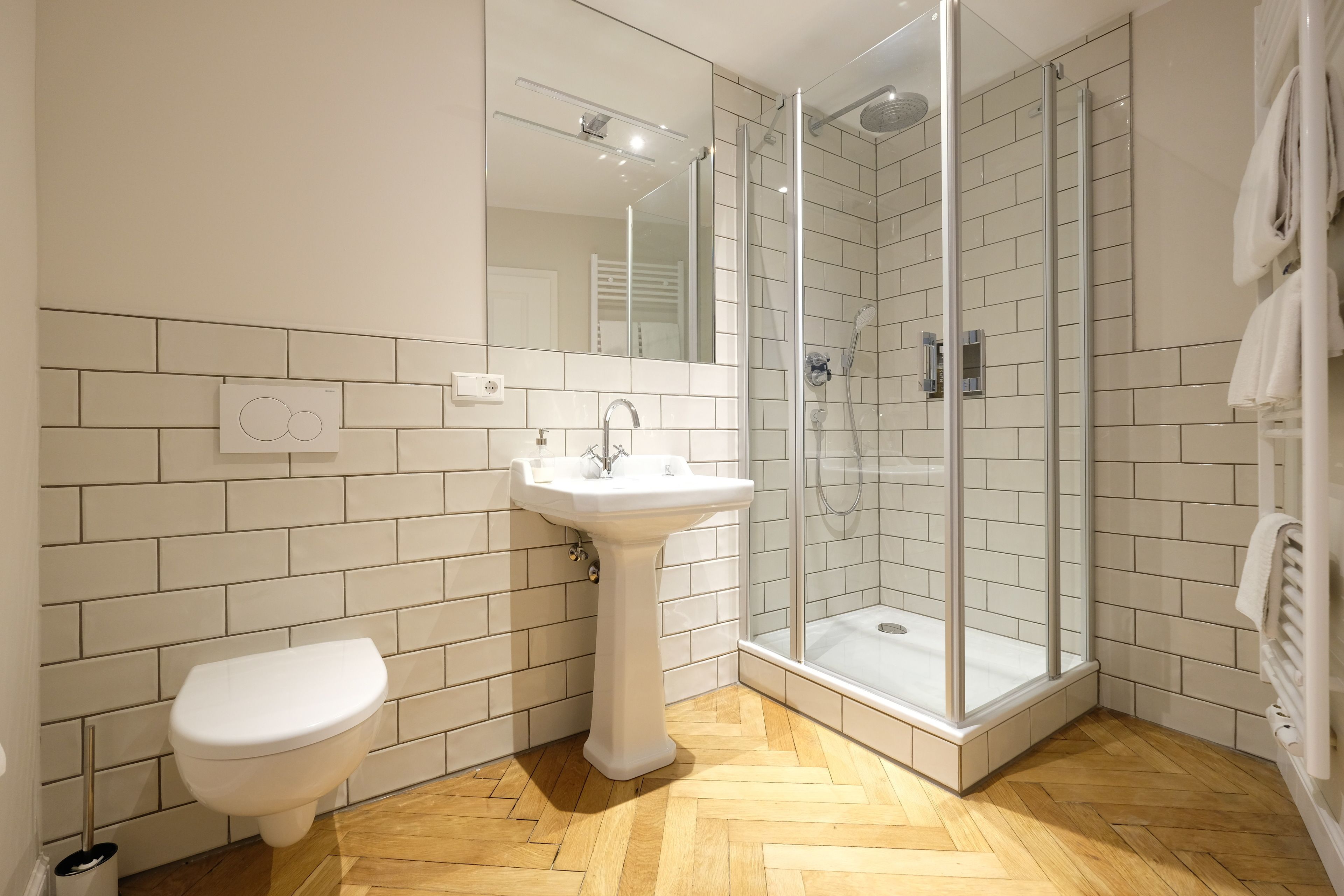 A bathroom with a white sink, toilet, and glass-enclosed shower.