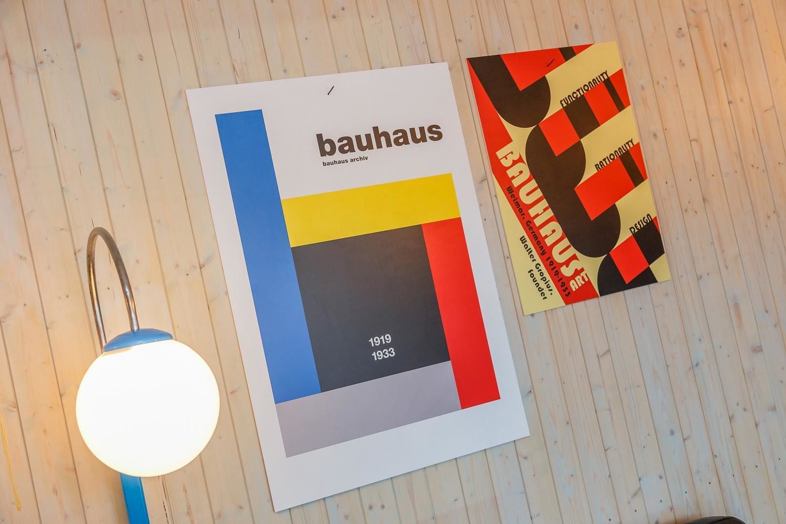A Bauhaus archive book and a lamp on a wooden surface.