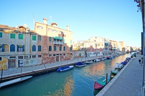 A canal with boats docked along the side, surrounded by historic buildings with balconies.