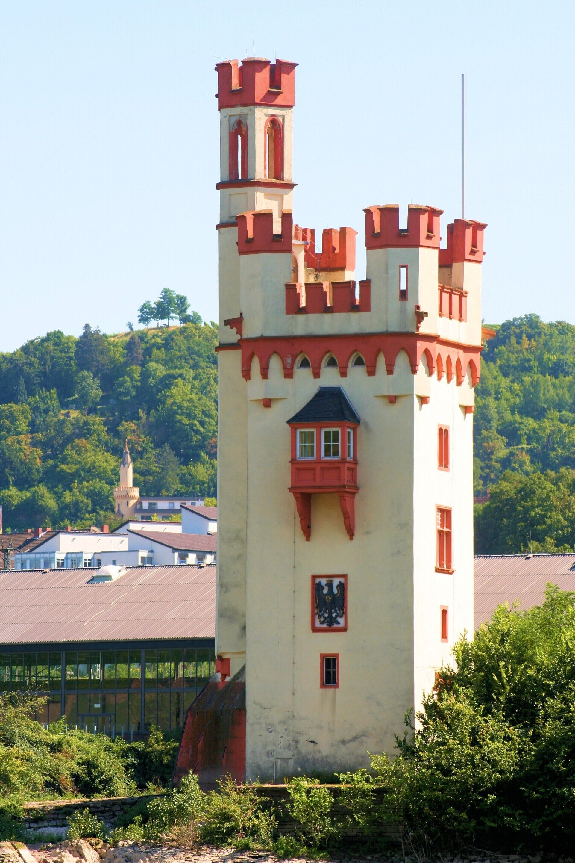 Un edificio que recuerda a un castillo, con una torre, ventanas y un pequeño balcón.