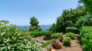 A garden with a view of the sea, terracotta pots, and various plants. - Villa Kommeno (Corfu)