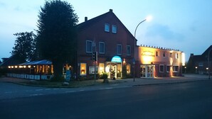 A two-story building with a sign for a hotel and restaurant. - Catharinenberg (Molfsee)
