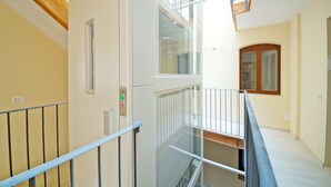 A multi-level interior with a glass railing, a wooden ceiling, and a light-colored wall. - DolceVita Apartments N. 443 (Venice)