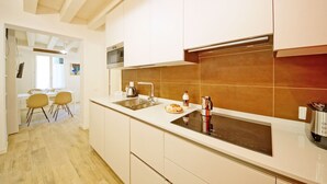 A modern kitchen with white cabinets, a double sink, and a built-in stovetop. - DolceVita Apartments N. 443 (Venice)