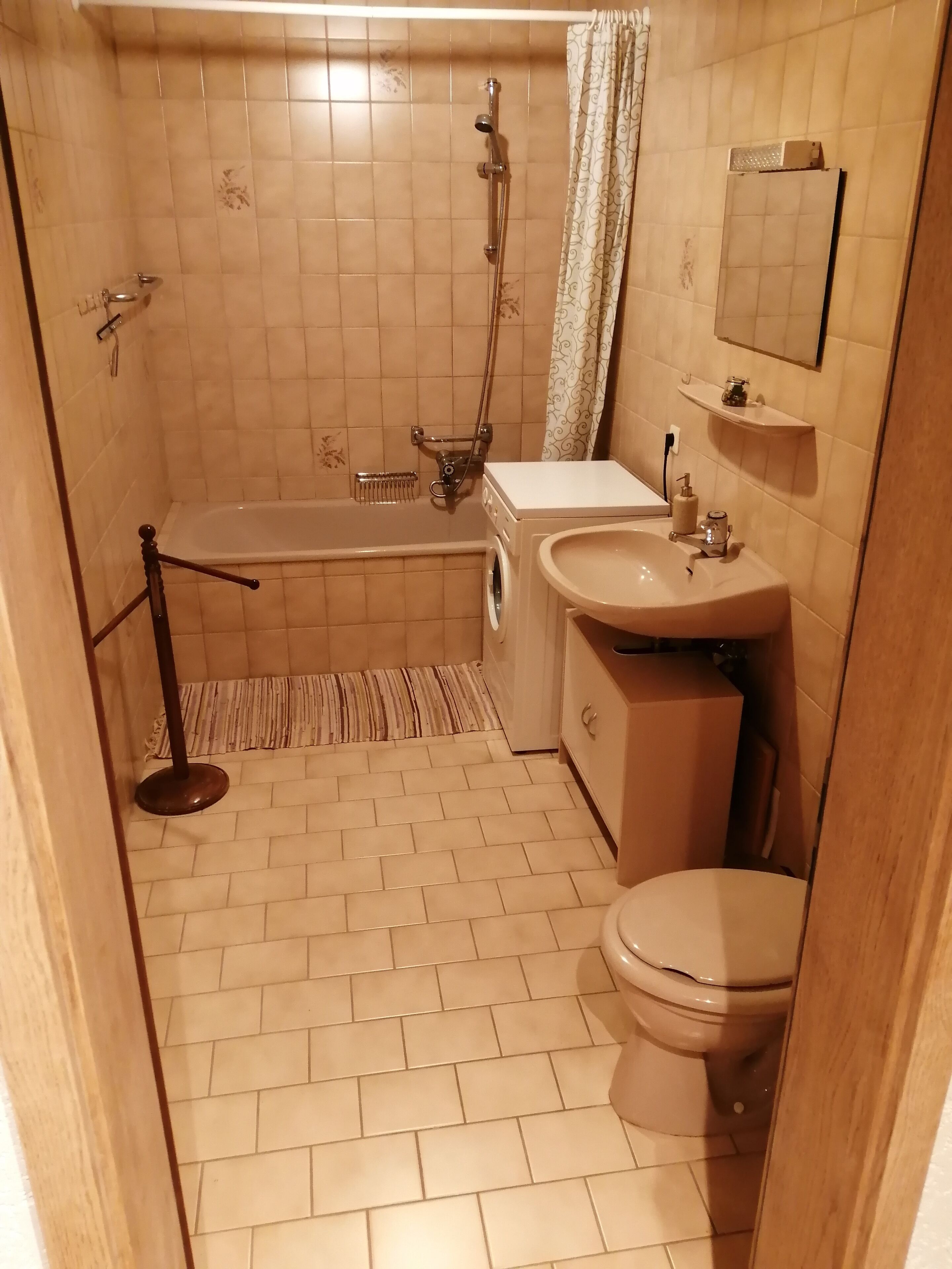 A compact bathroom with a bathtub, a sink, and a toilet.