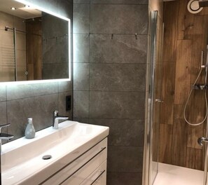 Apartamento, 2 quartos, sacada | Banheiro | Chuveiro, secador de cabelo, papel higiênico 