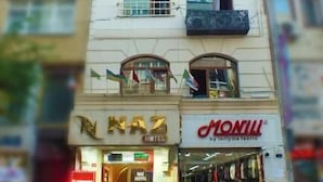 A hotel with multiple floors, balconies, and a storefront with a visible sign. - Naz Hotel (Istanbul)