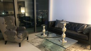 A modern living room with a glass coffee table, a leather sofa, and a patterned armchair. - Amazing Luxury Apartment at the 5 Star Hotel (Miami)