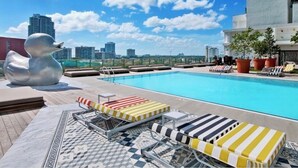 A rooftop pool with lounge chairs and a large abstract sculpture. - Amazing Luxury Apartment at the 5 Star Hotel (Miami)