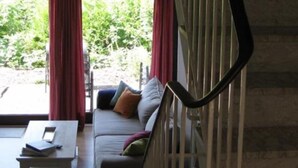 Una habitación con un sofá, una mesa de centro y una escalera.