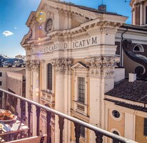 A historic building with ornate architecture, including a balcony with a railing and a table with pastries.