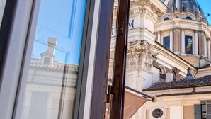 Una vista attraverso una finestra di un edificio dall'architettura classica, con una cupola e colonne.