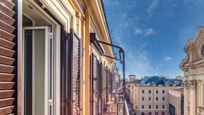 Una stretta via fiancheggiata da edifici storici, tra cui un edificio con la scritta "DI VIRO STET CALO".