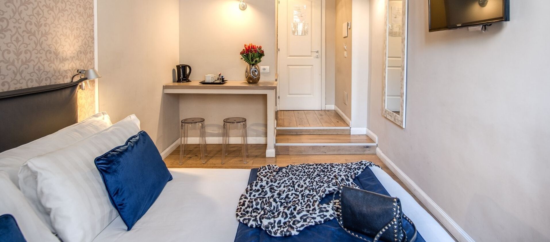 Een hotelkamer met een bed, een bank, een koffiehoek en een televisie.