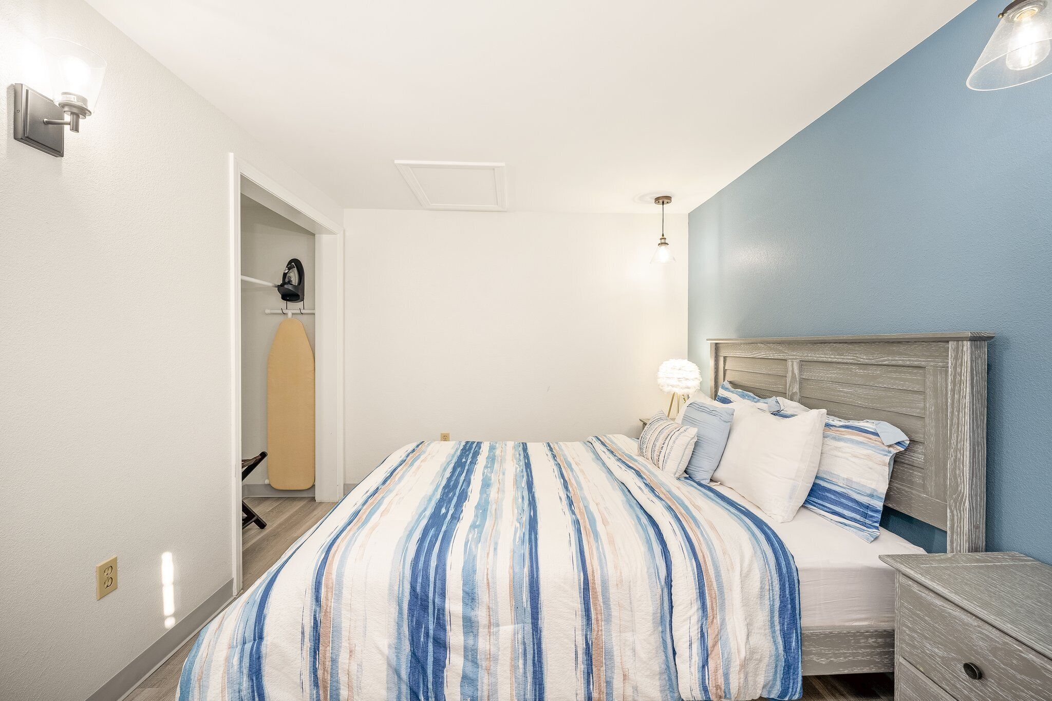 Ein Schlafzimmer mit Bett, Nachttisch und Beistelltisch.