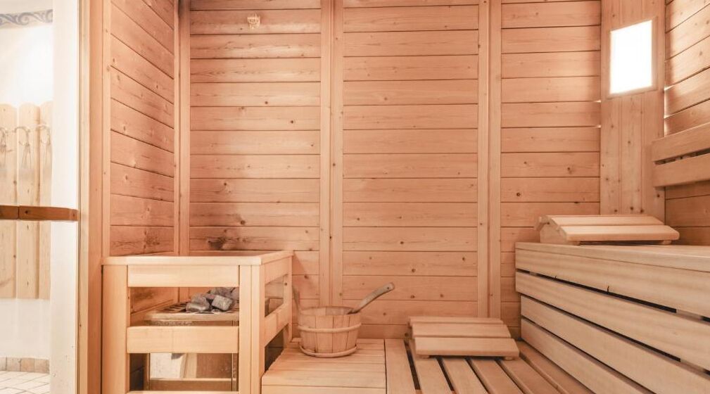 Eine Holzsauna mit Bänken und einem Holztisch.