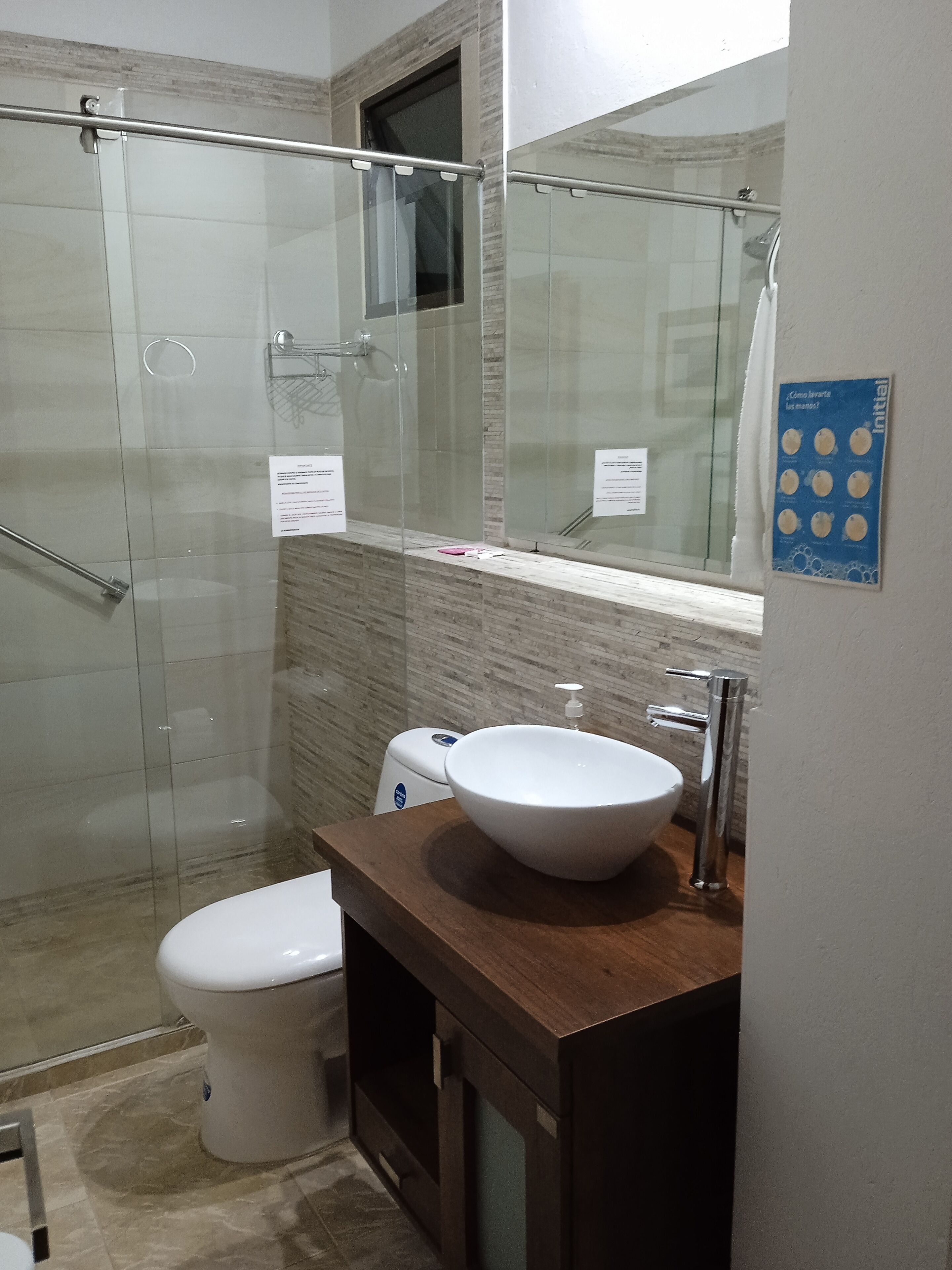 Une salle de bain moderne avec une douche à parois de verre, un lavabo blanc et des toilettes.