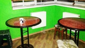 A room with two round tables, a stool, and a window with blinds. - Yourhostel Saperka (Kyiv)