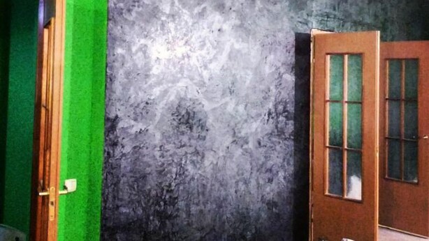 A room with a green door, a textured gray wall, and a wooden door with glass panels. - Yourhostel Saperka (Kyiv)