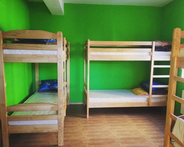 A room with two bunk beds against green walls, wooden flooring, and a white ceiling. - Yourhostel Saperka (Kyiv)