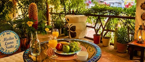 A table set with a fruit plate, glasses, a vase, and a sign reading 'Media Luna Suite'.