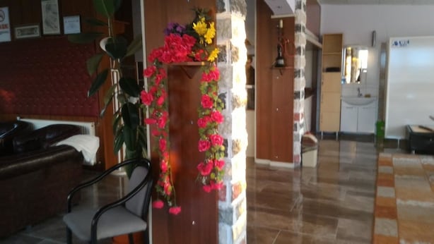 A hotel lobby with a reception desk, a seating area, and a decorative floral arrangement. - Gelibolu Kocoglu Hotel (Gallipoli)