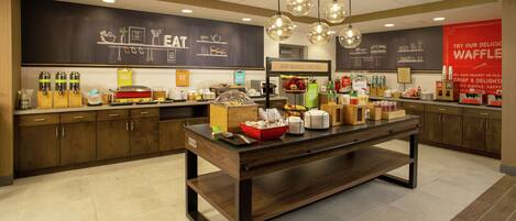 A modern kitchen area with a central island, various food items, and kitchen appliances.