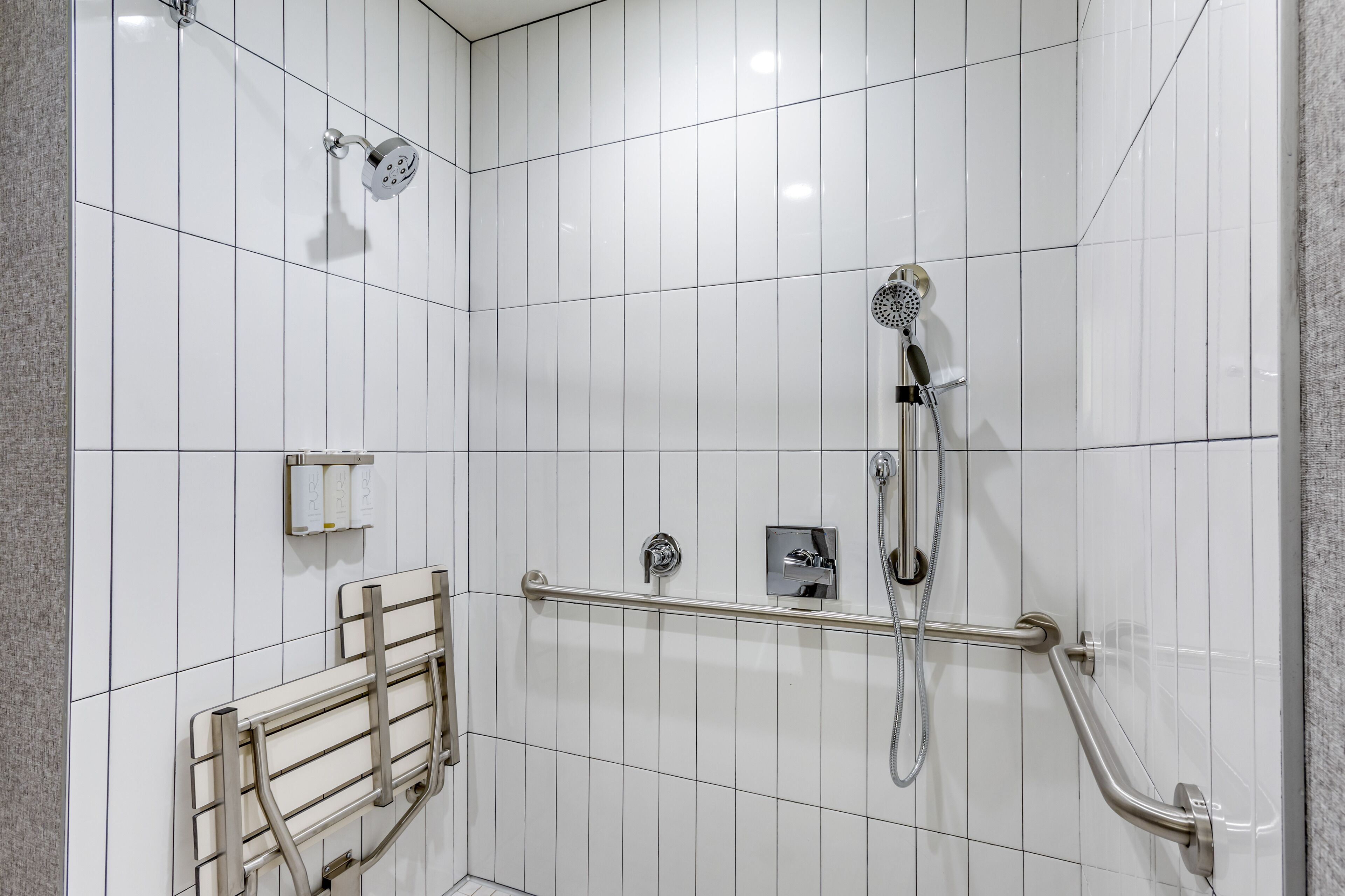 A modern bathroom with white tiled walls, a shower with a handheld showerhead, a handheld showerhead, a handheld showerhead, a handheld showerhead, a handheld showerhead, a handheld showerhead, a handheld showerhead, a handheld showerhead, a handheld showerhead, a handheld showerhead, a handheld showerhead, a handheld showerhead, a handheld showerhead, a handheld showerhead, a handheld showerhead, a handheld showerhead, a handheld showerhead, a handheld showerhead, a handheld showerhead, a handheld showerhead, a handheld showerhead, a handheld showerhead, a handheld showerhead, a handheld showerhead, a handheld showerhead, a handheld showerhead, a handheld showerhead, a handheld showerhead, a handheld showerhead, a handheld showerhead, a handheld showerhead, a handheld showerhead, a handheld showerhead, a handheld showerhead, a handheld showerhead, a handheld showerhead, a handheld showerhead, a
