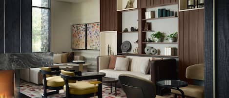 Un salon moderne doté d’une cheminée, de sièges confortables et d’étagères décoratives.