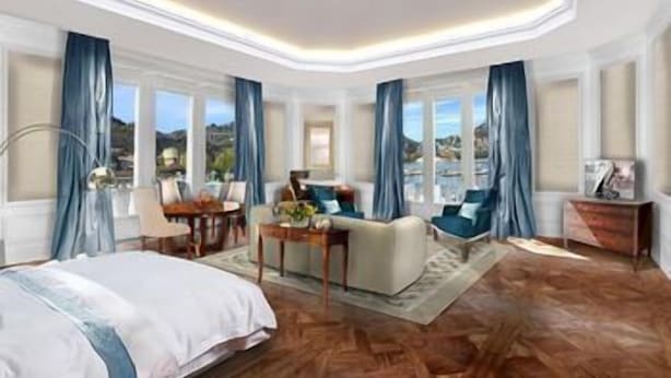 A spacious bedroom with a large bed, a sitting area with a table, and a view of the sea. - Vista Palazzo, Lago di Como (Como)