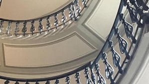 A curved staircase with ornate metal railings and decorative molding. - Vista Palazzo, Lago di Como (Como)